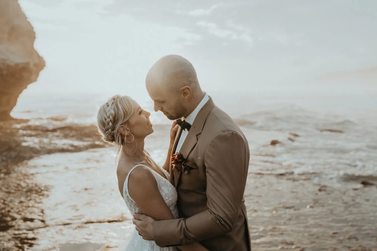 Talia and Brad together in warm light beside the ocean